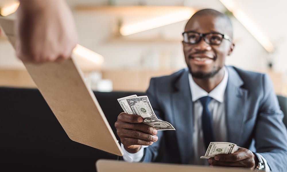A man with cash in his hands symbolizing real cash flow
